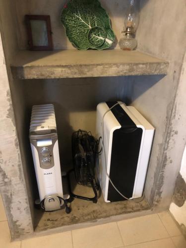 ein Regal mit einem Drucker und anderen Geräten darauf in der Unterkunft Xaminé in Água Retorta