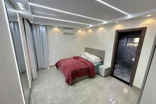 a bedroom with a bed with a red blanket at Yassoo fa in Zāwiyat al Habbābīyah