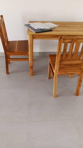 a wooden table and a chair sitting next to a table at Miramont Club Villas in Nungwi