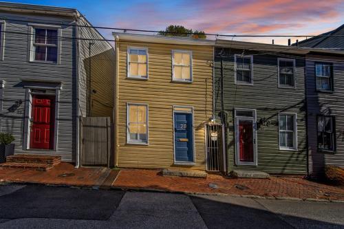a yellow house with two red doors on a street at Naval Academy Gate 1 in Annapolis