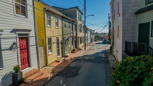 a narrow street with colorful houses and a red door at Naval Academy Gate 1 in Annapolis