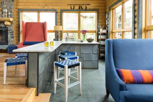 a kitchen with a counter and two blue chairs at The Bivvi Hostel in Breckenridge