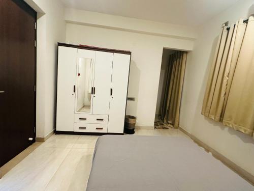 a room with a white cabinet and a mirror at Aarudhra villa in Chennai