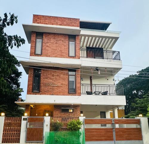 a tall brick building with a fence in front of it at Aarudhra villa in Chennai