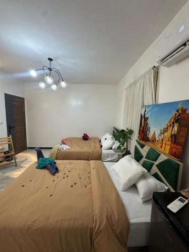 a bedroom with two beds and a painting on the wall at king pyramids in Cairo