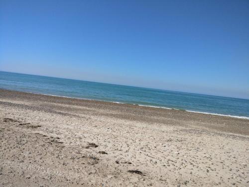 an empty beach with the ocean in the background at 6 person holiday home in Brovst in Brovst