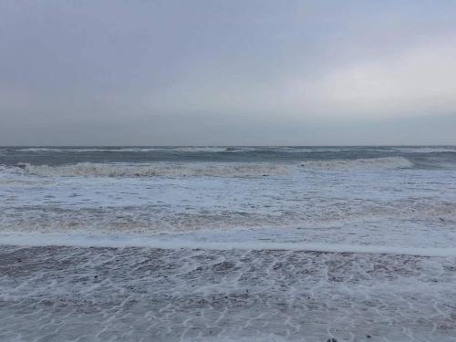 a sandy beach with waves in the ocean at 10 person holiday home in Fjerritslev-By Traum in Fjerritslev