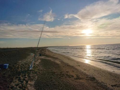 a beach with the sun setting on the water at 10 person holiday home in Fjerritslev-By Traum in Fjerritslev