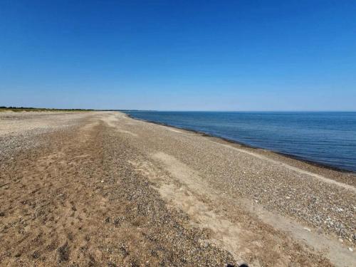 an empty beach with the ocean in the background at 10 person holiday home in Fjerritslev-By Traum in Fjerritslev