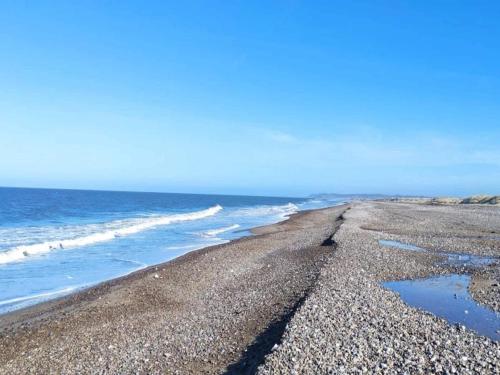 a rocky beach with the ocean in the background at 10 person holiday home in Fjerritslev-By Traum in Fjerritslev