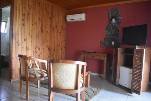 a living room with a chair and a television at Hotel Puku Vai in Hanga Roa