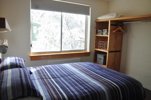 a bedroom with a bed and a window at Ripparoo Lodge in Falls Creek