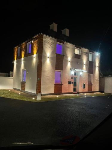 a large brick building with purple windows at night at TGHA Luxury Apartments in Athlone in Athlone