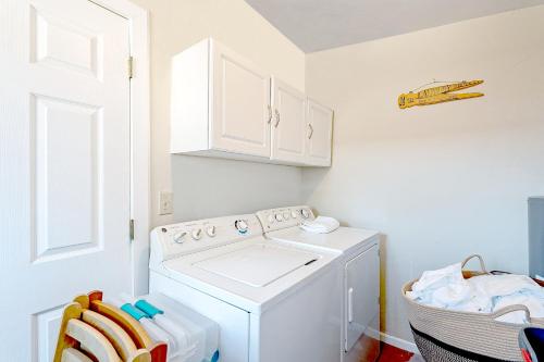 a laundry room with a washing machine in a room at Charming Basement Studio Guesthouse 2 Blocks from UofA, Low Summer Rates! in Tucson