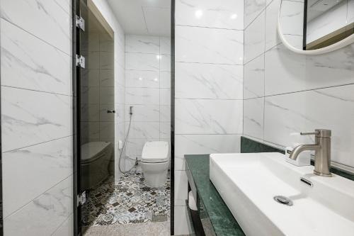 a white bathroom with a sink and a toilet at 호텔 시그니처 in Yangsan