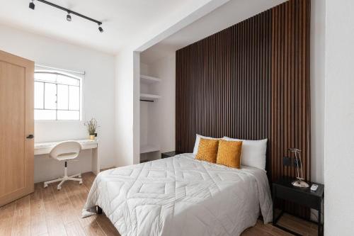 a bedroom with a large bed and a desk at Casa 212 con WIFI alta velocidad y estacionamiento in Puebla