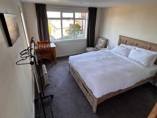 a bedroom with a large bed with a camera on a tripod at Sea Views Studio in Dunedin