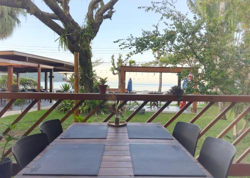 a table and chairs on a deck with a view of the beach at Hotel Porto Di Mare in Ubatuba