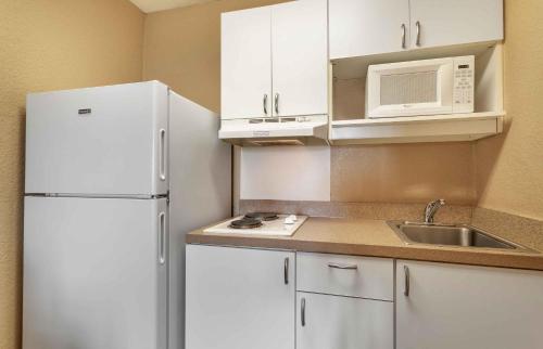 a kitchen with white cabinets and a white refrigerator at Extended Stay America Select Suites - Nashville - Airport in Nashville