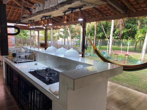 a kitchen with a stove and a hammock in a yard at Casa de Praia em Joanes - Salvaterra in Joanes