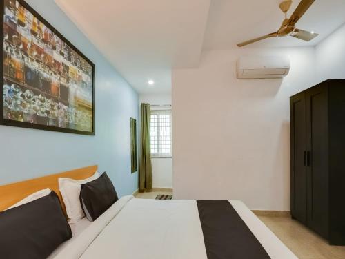 a bedroom with a bed and a ceiling fan at Super Townhouse Qualia Prime in Hyderabad