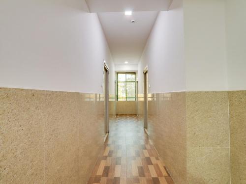 an empty hallway with tile walls and a window at Super Townhouse Qualia Prime in Hyderabad