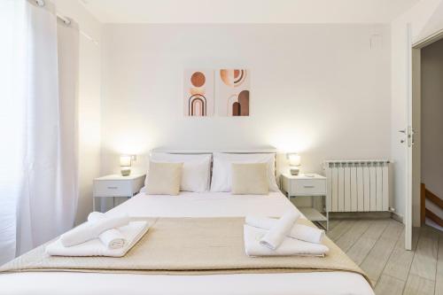 a white bedroom with a large bed with two night stands at Ganga House - Mini Loft Moderno-Free Parking in Lastra a Signa