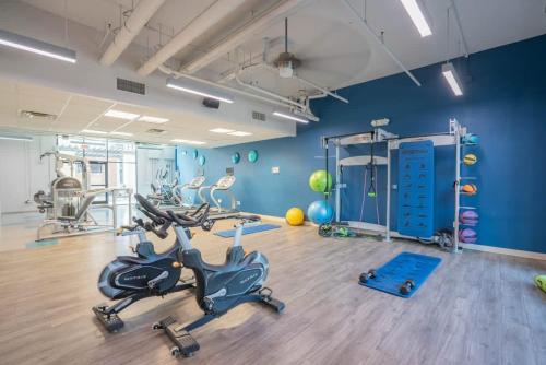 Un gimnasio con bicicletas estáticas en una habitación con paredes azules en Spacious Near ASU Sloan Pk Gym Parking Pool WD, en Tempe