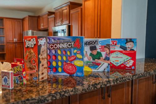 a kitchen counter with boxes of cereal and games at Spacious Near ASU Sloan Pk Gym Parking Pool WD in Tempe