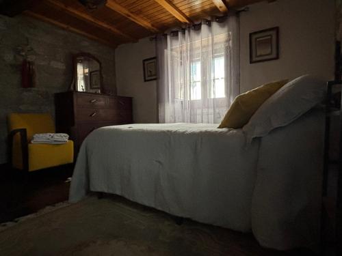 a bedroom with a white bed and a window at Albergue Rectoral de Romean in Lugo