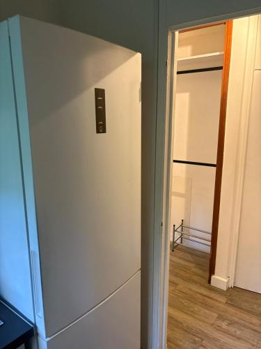a white refrigerator in a room with a door at Bas-du-Fort beach side in Le Gosier