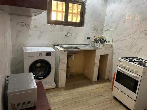 una cocina con fregadero y lavadora en Appartement meublé, en Lomé