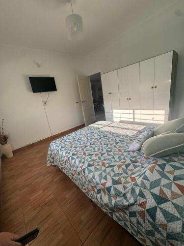 a bedroom with a bed and a flat screen tv at Casa Caelum in Concepción del Uruguay