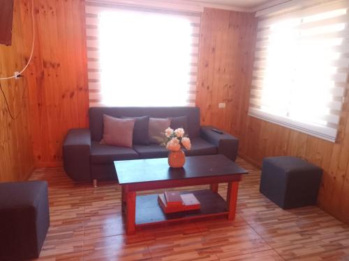 a living room with a couch and a coffee table at Cabaña Puipuyen Yerbas Buenas 