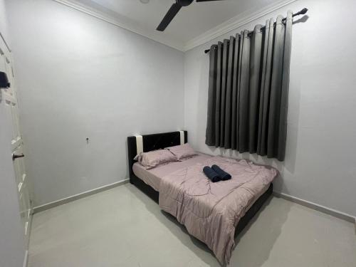 a small bedroom with a bed in a room at Casa De Harmoni in Pasir Puteh