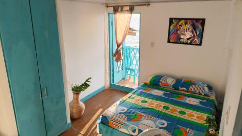 a bedroom with a bed and a painting on the wall at Renacer ancestral Barú in Playa Blanca