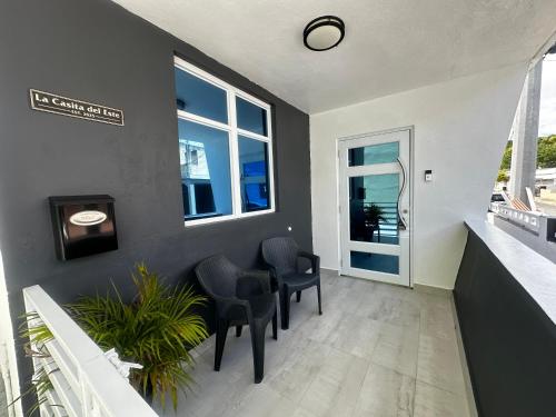 a room with two chairs and a wall with windows at La Casita del Este in Fajardo