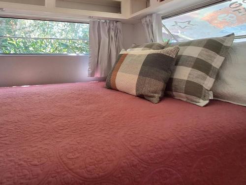 Un dormitorio con una cama con dos almohadas encima. en Vintage Coral Green, en Nelly Bay