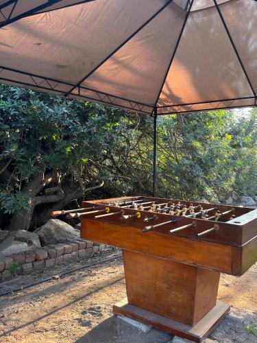 a wooden game table with an umbrella over it at Rosa Estela in Cieneguilla