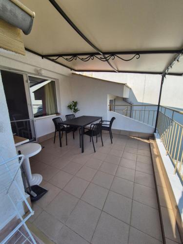 a patio with a table and chairs on a balcony at Апартамент за гости Роси in Sinemorets