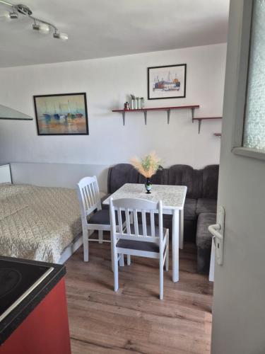 a living room with a table and chairs and a couch at Апартамент за гости Роси in Sinemorets
