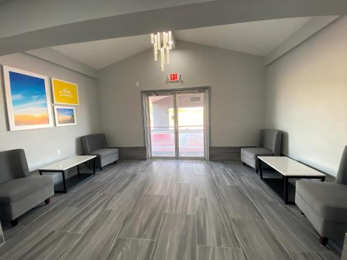 an empty waiting room with couches and a door at Days Inn & Suites by Wyndham Texas City in Texas City