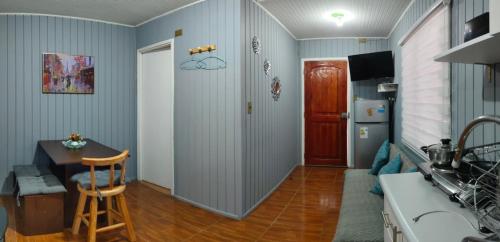 a living room with a table and a kitchen at Departamentos Entre Lagos in Licán Ray