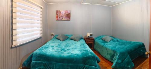 a bedroom with two beds and a window at Departamentos Entre Lagos in Licán Ray