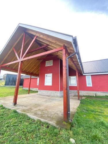 a red barn with a large open roof at Refugio del viajero, ideal para familias grandes in Puerto Varas