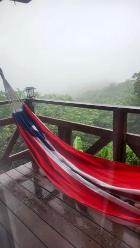 a red and blue hammock on a wooden deck at Mi Verde Horizonte in Utuado