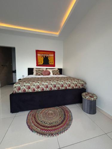 a bedroom with a large bed and a rug at Paradijs in Paramaribo in Paramaribo