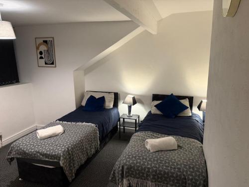 a bedroom with two beds with blue pillows at 4BR - 8 Beds - Free Parking - Long stay Discounts in Killingbeck