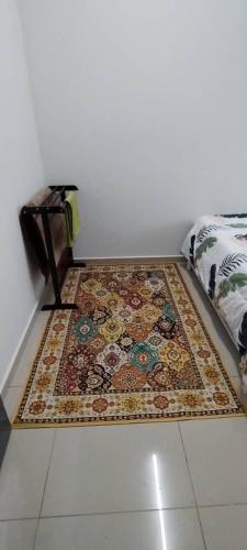 a rug on the floor next to a bed at Sobey Laris Homestay PASIR MAS in Pasir Mas