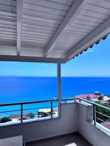 a balcony with a view of the ocean at Sevilia Rooms in Qeparo